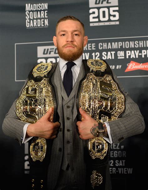 conor mcgregor holding 2 belts.